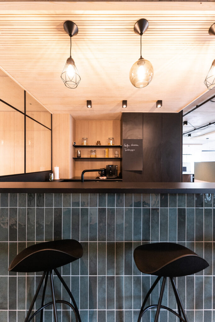 Küche der Bürofläche in Moosburg mit Theke, Barhockern und Kaffeevollautomat