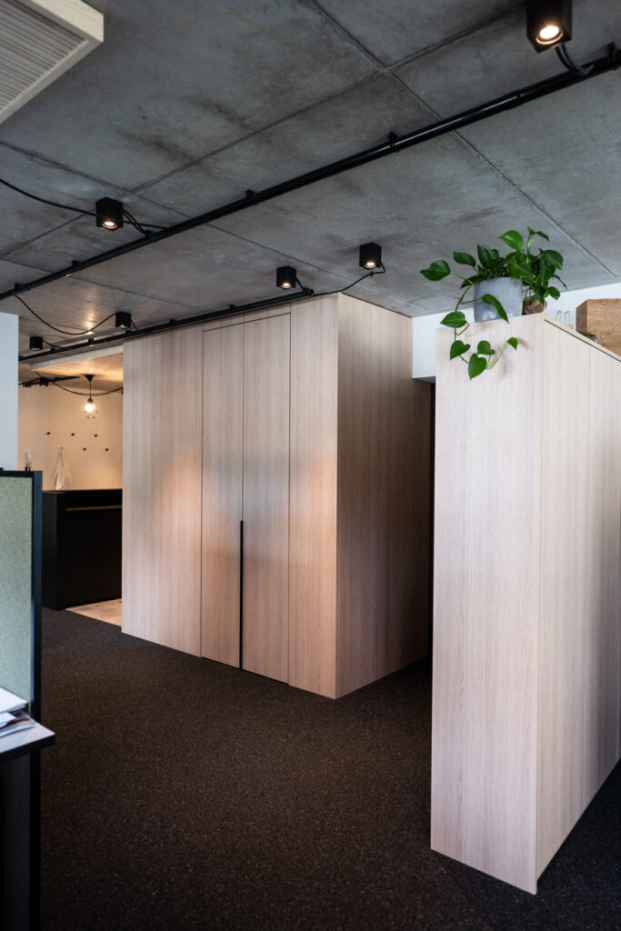 Einbauschränke und Stauraum unter der Sichtbetondecke im Büro in Moosburg